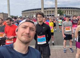 A man taking a selfie photo surrounded by fun runners