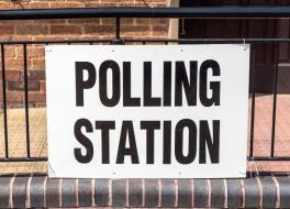 A sign saying 'Polling station' attached to railings