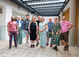 Five men and four women standing together and smiling