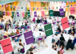 Bunting, with the word 'STAMMA' on it, with a backdrop of a busy dinner hall