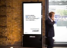 A digital advertisement board in a busy train station