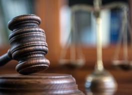 A gavel and block, in a courtroom setting