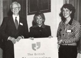 A man and two women holding a banner with 'British Stammering Association' on it