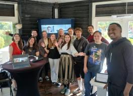 A group of people standing together in a room and smiling