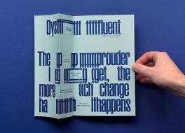 A folder piece of paper with text on it, and a hand holding it