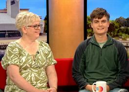 A mother and son sitting on a sofa