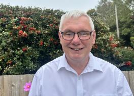A man in a garden, smiling