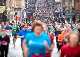 A huge crowd of people running through a street as part of a sponsored run