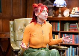 A young woman sitting in an armchair with her arms open