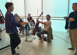 Members of an orchestra rehearsing and chatting