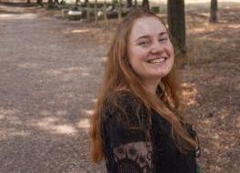 A young woman in a park, smiling