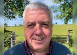 A man in the countryside, smiling
