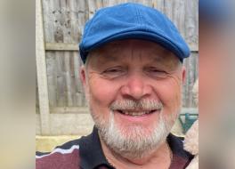 A man wearing a cap and smiling