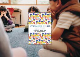 A book cover, with a backdrop of young children sitting in a room