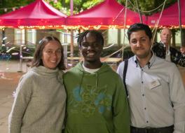 A woman and two men standing side by side and smiling