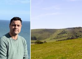 A man with the ocean behind him, next to a field in the Sussex countryside