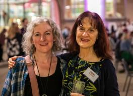 Two women standing next to each other and smiling
