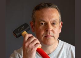 A man holding up a hammer