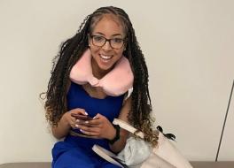 A young woman holding a mobile phone and smiling