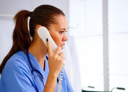 A female nurse speaking into a telephone