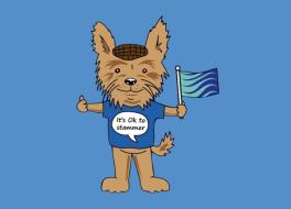 An illustrated dog wearing a t-shirt and flat cap, holding a flag. On its t-shirt it says 'It's okay to stammer'