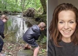 Two boys next to a woodland stream. A smiling woman's face is net to them