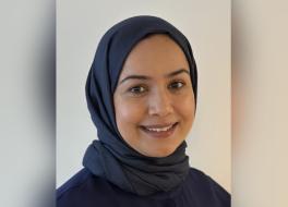 A woman wearing a headscarf, smiling