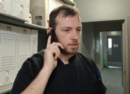 A man speaking into a telephone and looking frustrated
