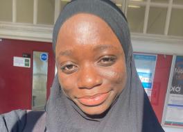 A woman in a headscarf, smiling