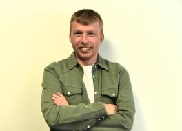 A man with his arms folded, and smiling