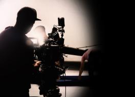 A camera operator filming a set