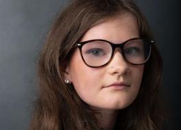 A woman wearing glasses smiling