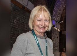 A woman wearing a lanyard and smiling