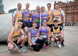A group of people in running costumes posing for the camera