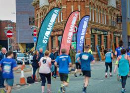 People on a sponsored run, with spectators cheering them on