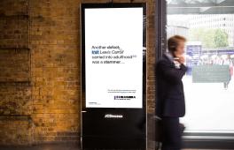 A digital advertisement board in a busy train station