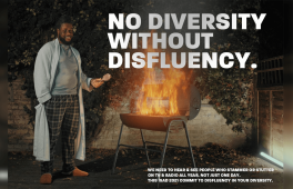 A man standing next to a barbecue that has flames coming out of it.