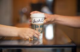 A Starbucks coffee cup handed over the counter