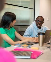 A man talking to a woman at a desk in an office