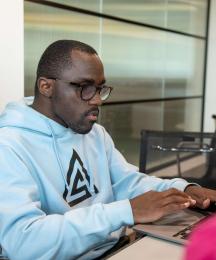 A man sitting at a desk working on a laptop