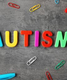 Brightly coloured letters spelling out the word 'Autism', with pens and paperclips around it