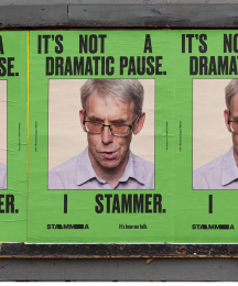 Three billboard posters featuring a man's face with the text 'It's not a dramatic pause. I stammer' above and below them