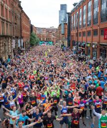 A street full of charity runners all looking at the camera waving their hands
