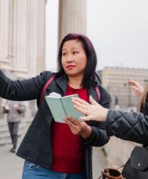A woman giving directions to another woman in the street