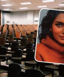 A woman smiling, with an empty lecture theatre as a backdrop