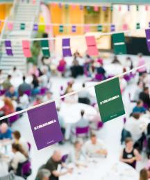 Bunting, with the word 'STAMMA' on it, with a backdrop of a busy dinner hall