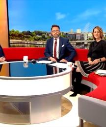 TV presenters on a sofa interviewing a woman