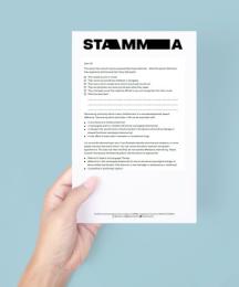 A hand holding a piece of paper with text on it