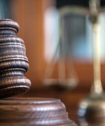 A gavel and block, in a courtroom setting