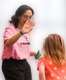 A woman high fiving a young girl, who's back is to the camera